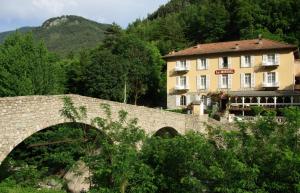 a building and a bridge in front of a mountain at Le Mirval in La Brigue