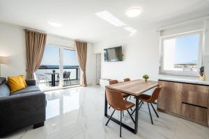 a living room with a table and a couch at Poolside Hideout Apartments in Novalja