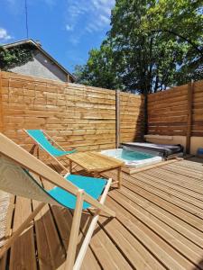 a deck with two chairs and a swimming pool at Le Chalet Champenois - Jacuzzi - Terrasse - Calme - Ciné Netflix in Troyes
