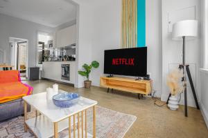 a living room with a tv and a couch at 2-Bedroom House Hoolloomooloo Good for 6 Guests in Sydney