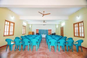 a room with blue chairs and a ceiling at YMCA International Youth Programme Centre & Guest house in Kovakulam