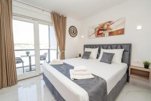 a bedroom with a large bed and a balcony at Poolside Hideout Apartments in Novalja +37 photos