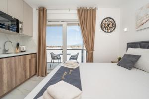 a bedroom with a large bed and a balcony at Poolside Hideout Apartments in Novalja