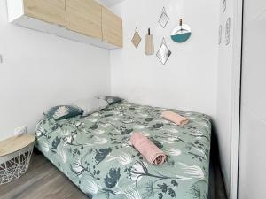 a bedroom with a bed with a green and white blanket at Studio à Montluçon in Montluçon