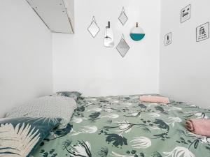 a bedroom with a bed with a green and white blanket at Studio à Montluçon in Montluçon