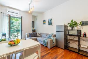 cocina y sala de estar con mesa y nevera en Deluxe & Elegant Apt with all Comfort and View, en Milán