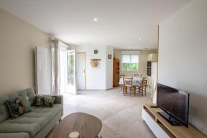 a living room with a couch and a tv at La belle etoile in Saint-Aulaye