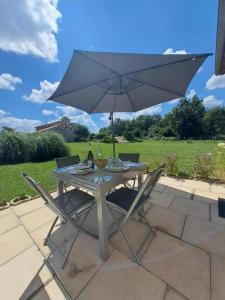 a table with an umbrella on a patio at La belle etoile in Saint-Aulaye