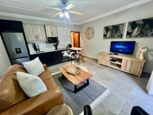 a living room with a couch and a table at Little Eden Apartments St Lucia in St Lucia