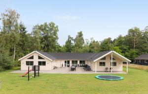 a white house with a playground in the yard at Holiday Home Frederiksværk - 01 in Melby +28 photos