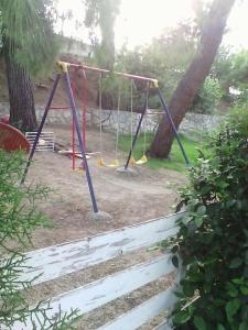 a swing set in a yard with trees at Avra Ηouse in Kriopigi