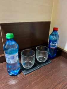 two bottles of water and two empty glasses on a table at Studio Chic Elena in Năvodari +13 photos