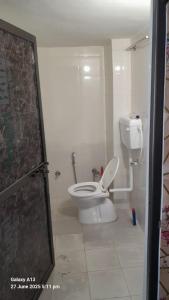 a bathroom with a white toilet in a room at Shri Satyanarayan ji homestay in Ayodhya