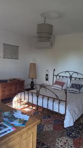 Un dormitorio con una cama y una mesa con una lámpara. en Le mas des louquiers, en Mons