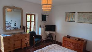 Un dormitorio con una cómoda, un espejo y una silla. en Le mas des louquiers, en Mons