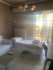 a room with a table and a couch and a window at Monemvasia Lazarus Beach Apartment in Monemvasia