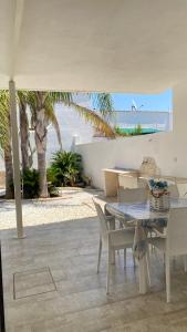 una sala da pranzo con tavolo e sedie e la spiaggia di Albachiara a Sant'Isidoro