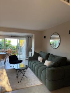 a living room with a green couch and a table at Mas Provençal - sea view - Lauva Terraces in Sainte-Maxime