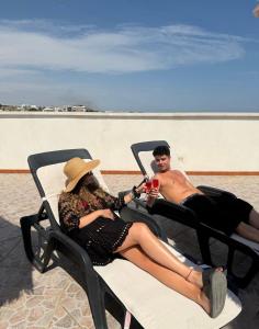 a man and a woman sitting in chairs on the beach at Al Vecchio Frantoio al Mare in Monopoli