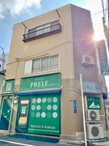 a building with a sign on the side of it at HOTEL PRELE Asakusa ホテルプレール浅草 in Tokyo