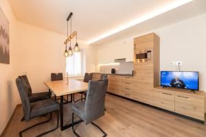 a dining room with a table and a tv at Casa di Gio in Cavalese