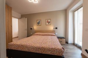 a bedroom with a bed and a large window at Casa di Gio in Cavalese