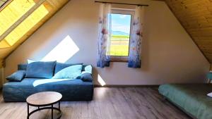 a living room with a couch and a window at Kaczawska Chata z wypożyczalnią e-hulajnóg terenowych 