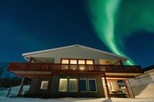 a house with the aurora in the sky at Abisko Hostel in Abisko