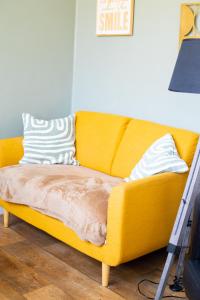 a yellow couch in a living room with a lamp at Appt 2 ch, Quartier Port de Calais, tout à pied in Calais