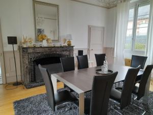 ein Esszimmer mit Tisch und Stühlen und einem Kamin in der Unterkunft Chez Delphine et Bob -Ancienne Maison de Tanneurs in La Suze-sur-Sarthe