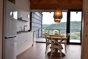 a kitchen with a table with chairs and a large window at La Finca del Valle 