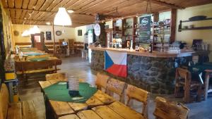 a restaurant with tables and a bar with a flag on the wall at Penzion Jaroš in Popůvky