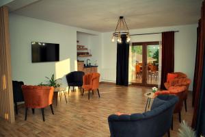 a living room with orange chairs and a dining room at Casa Anto in Călimăneşti
