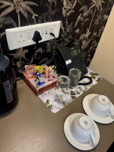 a table with plates and a telephone on it at Aerodrome Lodge and Conference Centre in Benoni