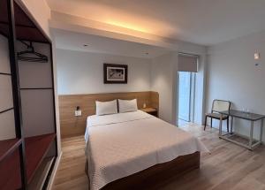 a bedroom with a bed and a desk and a window at The Charm Boutique Hotel in Hue in Cồn Giả Viên