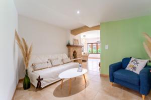 a living room with a white couch and a blue chair at La Bonbonnière Gîte De Charme in Malaucène