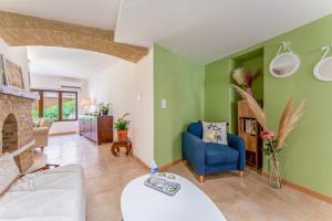 a living room with green walls and a blue chair at La Bonbonnière Gîte De Charme in Malaucène