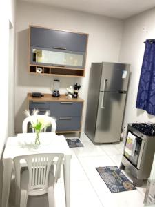 a kitchen with a table and a stainless steel refrigerator at Cacau estadia in Canindé de São Francisco