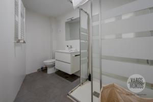 baño blanco con aseo y ducha acristalada en Descubre Madrid para 5, al pie de Gran Vía E2, en Madrid 16 fotos más