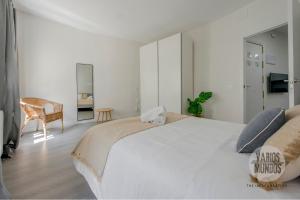 Un dormitorio blanco con una cama grande y una silla. en Descubre Madrid para 5, al pie de Gran Vía E2, en Madrid