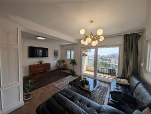 a living room with a couch and a large window at Penthouse NIKOLA in Budva