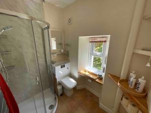 baño con aseo y ducha y ventana en Wood Cottage, en Peebles 33 fotos más