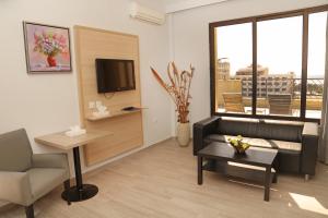 a living room with a couch and a table and a tv at Golden Lotus hotel by Trend in Aqaba