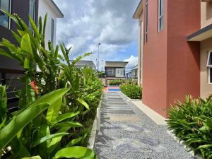 un sendero ajardinado entre dos edificios con plantas en DesaruTropInnCorner BBQHut LuxPool Hoops&KTVPartyON, en Bandar Penawar