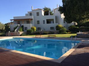 a villa with a swimming pool in front of a house at Xenon Estate in Spetses
