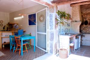 a kitchen with a blue table and chairs in a room at O Quinteiro de Elvira in Moaña +76 photos