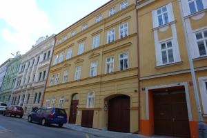 a yellow building on the side of a street at Limes Apartments in Prague