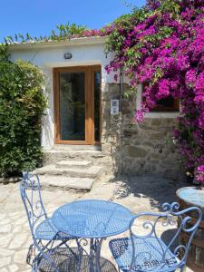 Áyios PandeleḯmonMoani的一张桌子、两把椅子和一扇带花的门