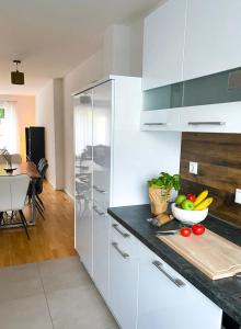 a kitchen with white cabinets and a bowl of fruit on a counter at MODERN LIVING Haus mit 3 Schlafzimmern für bis zu 7 Personen in Regensburg