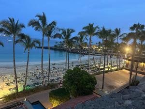 a view of a beach at night with palm trees at Anfi Beach in Mogán